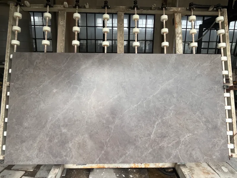Dark grey slab with fine white veining held on a storage rack with white rollers