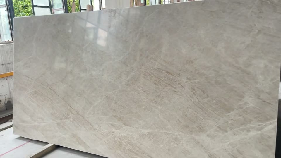 Camera moving across a finished warm grey slab in the workshop